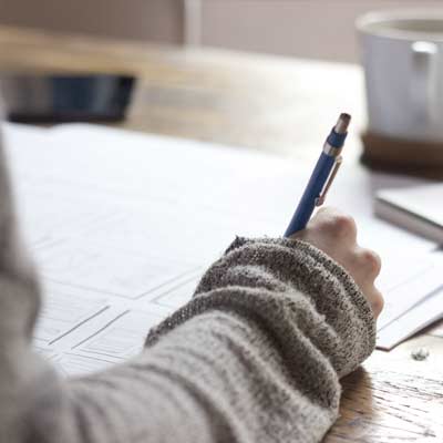 person writing, pen and pad